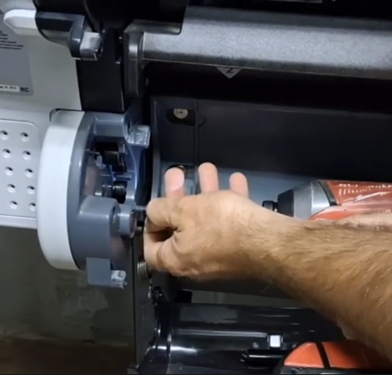 Technician replacing a part inside an HP Designjet plotter